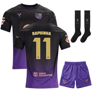## Maillot Barca Kit Enfant Exterieur 2026/2027 Raphinha ### Un kit extérieur complet pour les jeunes fans du Barça Le Maillot Barca Kit Enfant Exterieur 2026/2027 Raphinha reprend l'identité moderne de la nouvelle tenue extérieure du FC Barcelone. Son maillot noir évolue progressivement vers un violet profond, avec des détails dorés qui soulignent le flocage Raphinha et le numéro 11 au dos. ### Un ensemble sportif aux couleurs du FC Barcelone Pensé pour offrir une tenue complète, ce kit associe le maillot extérieur à un short violet assorti et à des chaussettes coordonnées. La texture graphique discrète du maillot apporte du relief à sa base sombre, tandis que les touches violettes et dorées créent un contraste élégant sur l'ensemble. ### Raphinha et le numéro 11 à l'honneur À l'arrière du maillot, le nom Raphinha apparaît au-dessus du numéro 11 dans une finition dorée. Cette personnalisation permet aux jeunes supporters de porter les couleurs du Barça avec le nom de l'ailier brésilien, que ce soit pour jouer au football, s'entraîner ou afficher leur passion au quotidien. ### Le Maillot Barca Kit Enfant Exterieur 2026/2027 Raphinha * Kit enfant FC Barcelone * Version extérieure * Saison 2026/2027 * Flocage Raphinha * Numéro 11 * Maillot extérieur * Short assorti * Chaussettes incluses * Coloris noir et violet * Dégradé du noir vers le violet * Détails violets sur le maillot * Finitions dorées * Écusson du FC Barcelone * Sponsor Spotify * Logo Barça Foundation au dos * Texture graphique discrète * Matière légère * Coupe adaptée aux enfants * Disponible en plusieurs tailles enfant * Badges non inclus lors de l'achat * Code produit : FCB64827 ### Découvrez les autres tenues du Barça Pour compléter l'équipement des jeunes supporters ou découvrir d'autres modèles du club catalan, parcourez également [toute la collection de maillots du FC Barcelone](https://foot-star.com/categorie/maillot-barca/) avec les tenues domicile et extérieur, les différents kits enfant, les maillots personnalisés avec les joueurs ainsi que les shorts et chaussettes de la saison 2026/2027. ### Conseils d'entretien Pour préserver les couleurs du kit et la qualité du flocage Raphinha, lavez les différentes pièces à 30 °C sur l'envers avec des couleurs similaires. Évitez le sèche-linge et l'adoucissant, puis ne repassez pas directement sur le flocage, les logos, le sponsor ou les autres marquages.
